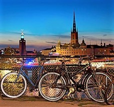 Bicycles parked at Slussen at night in Stockholm, with the city hall in background